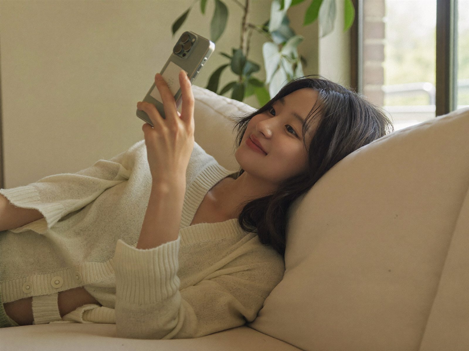 창가 책상에서 물 한 잔과 함께 노트를 쓰는 여성